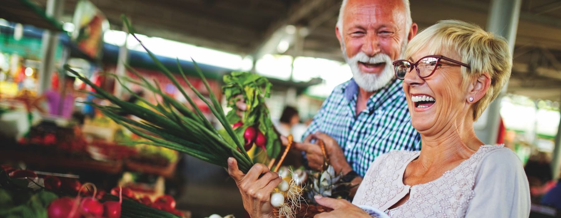a man and woman holding a basket of vegetables